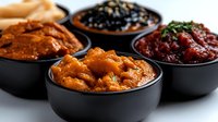 Assorted traditional fermented foods in black bowls including kimchi, black beans, and colorful pickled vegetables for healthy gut microbiome support.