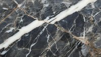 Dark marble surface with white and gold veining patterns creating elegant natural stone texture for luxury interior design and architectural applications.