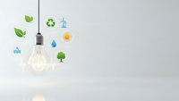 Glowing light bulb with colorful eco-friendly icons representing renewable energy sources and environmental sustainability on clean white background.