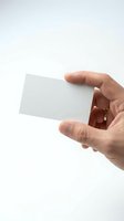 Hand holding blank white business card mockup template isolated on white background for branding and corporate identity design projects.