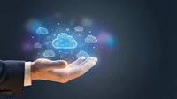 Businessman hand holding glowing cloud network icons, digital technology concept with blue light effects on dark background.