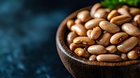 Fresh raw pinto beans in rustic wooden bowl on dark background with copy space, macro food photography for healthy eating and cooking blogs.