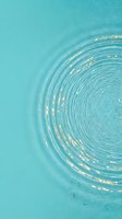 Turquoise water surface with golden circular ripples creating mesmerizing concentric patterns in tropical ocean or pool for relaxation and wellness designs.