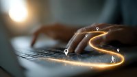 Close-up of hands typing on laptop keyboard with glowing digital path and location markers, concept of online navigation and digital journey.