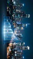 Nighttime cityscape with illuminated skyscrapers and digital holographic bar chart overlay representing financial growth, data analysis, and business analytics for corporate presentations.