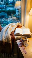 Cozy rainy day reading nook with open book, warm knit blanket, coffee mug, and thank you gift tag by a window.