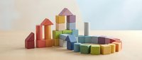 Colorful wooden building blocks arranged in towers and curved patterns on natural wood surface, isolated for educational toy and child development design projects.