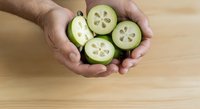Male hands holding fresh sliced cucumber pieces over wooden surface, showcasing organic produce for cooking, healthy eating, and food preparation concepts.
