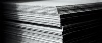 Stack of paper sheets in black and white showing layered edges and texture for office supplies, printing, documentation and business materials.