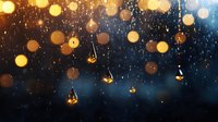 Glowing light bulbs hanging in rain against dark blue background with bokeh effect creates magical atmospheric mood for seasonal decoration.