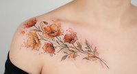 Delicate watercolor floral tattoo with orange poppies and botanical elements on woman shoulder, artistic body art design for feminine ink inspiration.