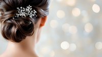 Elegant bridal updo hairstyle with crystal hair accessory against soft bokeh background, showcasing professional wedding hair styling and delicate hair ornament details.