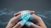 Hands holding glowing shield icon with digital security protection concept, cybersecurity and data safety for business technology.