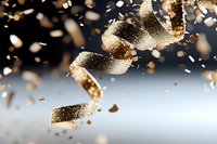 Golden confetti ribbons falling through air with sparkling glitter particles creating festive celebration atmosphere for party decorations and events.