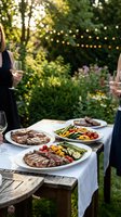 Outdoor dinner party with grilled steaks and vegetables on rustic table under string lights in garden setting for summer entertaining and dining.