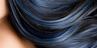 Close-up of wavy black hair with blue highlights showing smooth, glossy texture and natural movement against neutral background. Perfect for beauty and hair care designs.