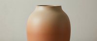 Terracotta ceramic vase with smooth rounded body and narrow neck opening, isolated on neutral background for home decor and design projects.
