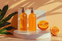 Orange cosmetic bottles with pump dispensers on white podium display with fresh citrus fruits and tropical leaves, beauty product mockup for natural skincare packaging design.