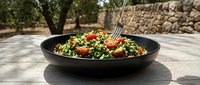 Vibrant tabbouleh salad with fresh parsley, tomatoes, and bulgur wheat in black bowl outdoors, Mediterranean cuisine for healthy eating.