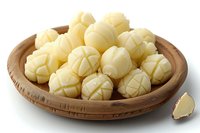 Fresh peeled garlic cloves arranged in wooden bowl on white background, raw organic ingredient for cooking and seasoning food preparation.