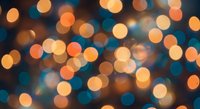 Warm golden and blue bokeh lights create dreamy blurred circles against dark background for festive holiday decorations and celebrations.