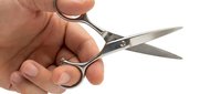 Close-up of a hand holding open scissors with sharp metal blades against a white background, suitable for office, craft, and educational design projects.