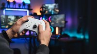 Gamer holding white wireless controller with blurred gaming setup and neon lighting in background, for gaming, esports, and entertainment content.