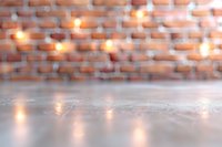 Blurred brick wall background with warm glowing lights and reflective concrete floor surface creates atmospheric mood for product photography and design layouts.