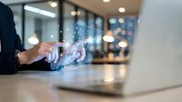 Business professional using laptop with digital network connections and data visualization in modern office environment for technology and communication concepts.