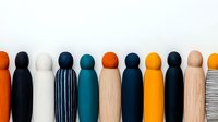 Minimalist wooden peg dolls in modern colors - teal, orange, natural wood, and black. Row of decorative figures showing contemporary design style.