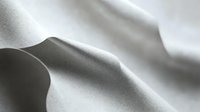 Sensual abstract macro photography of smooth white fabric folds creating gentle curves and shadows in monochromatic style, suitable for artistic and minimalist design projects.