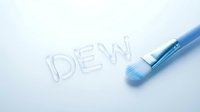 Dew written in water droplets with blue cosmetic brush on white surface for skincare and beauty product marketing.
