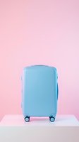 Light blue hardshell suitcase on a white podium against a pastel pink background, evoking travel, vacation, and modern style.