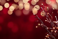 Festive red background with warm golden bokeh lights and decorative branches with berries for holiday celebrations and seasonal greeting cards.
