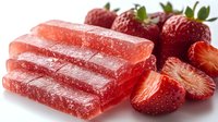 Homemade strawberry fruit leather strips with fresh ripe berries on white background, healthy natural snack food for kids and adults.