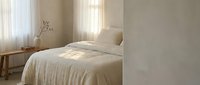 Serene minimalist bedroom with cream bedding, natural light from sheer curtains, wooden nightstand with dried flowers, and neutral walls for interior design projects.