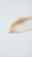 Smooth cream cosmetic texture stroke on white background for skincare and beauty product applications.