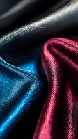 Luxurious silk fabric in deep blue and burgundy red colors with elegant folds and texture creating dramatic light effects. Suitable for fashion and luxury backgrounds.