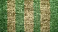Striped green and beige burlap fabric texture with natural jute fibers showing rough woven pattern. Raw organic material surface with vertical lines.