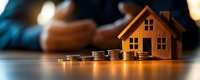 Wooden house model with stacked coins representing real estate investment, mortgage savings, property financing and home buying concept for financial planning.