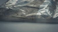 Close-up of cracked concrete surface with dramatic shadows and light patterns creating abstract textural composition for industrial design projects.