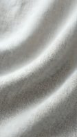 Soft beige linen fabric with natural wrinkles and folds showing organic textile texture for interior design and fashion projects.