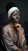 Young Asian woman applying clay face mask in spa robe with headband for skincare routine and beauty treatment relaxation.