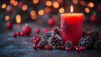 Glowing red candle with snowflake pattern surrounded by pine cones and cranberries against blurred bokeh lights background creates cozy winter holiday atmosphere.