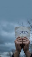 Hands holding handwritten sorry note against cloudy sky expressing apology, forgiveness and reconciliation concepts for emotional healing and relationships.