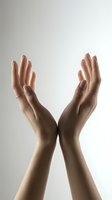 Female hands raised upward in graceful gesture against neutral background expressing hope, prayer, spirituality, wellness and positive energy for meditation concepts.