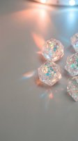 Sparkling crystal dice with rainbow light reflections creating magical prismatic effects on soft blurred background for gaming and fantasy concepts.