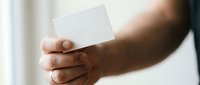 Hand holding blank white card for business branding, marketing mockup, or corporate identity design presentation.