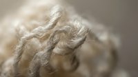 Twisted natural fiber rope or twine in close-up detail showing texture and woven strands for backgrounds, design elements, or craft projects.