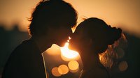 Romantic couple silhouettes touching foreheads at golden hour sunset with warm bokeh lights creating intimate moment for love and relationship concepts.